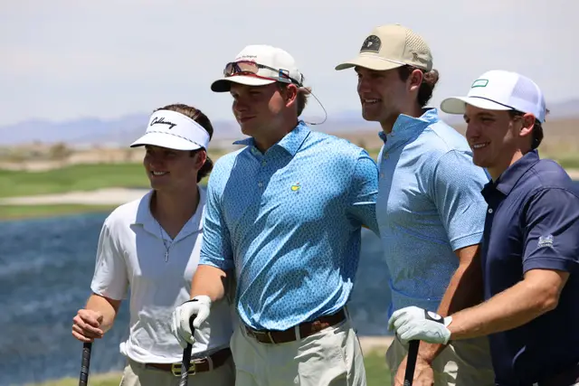 Four young golfers posing together beside the lake